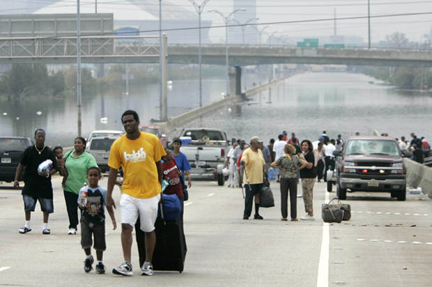 Residents of New Orleans rescued by police boats walk from floodwaters in front of the Superdome in New Orleans September 1, 2005. New Orleans Mayor Ray Nagin issues an urgent plea for relief, saying the flooded city lacks food for thousands of Hurricane Katrina's refugees as well as buses to evacuate them. REUTERS/Jason Reed JIR/mk FOR BEST QUALITY IMAGE: ALSO SEE GF2E54L176S01 - RTRM9IH